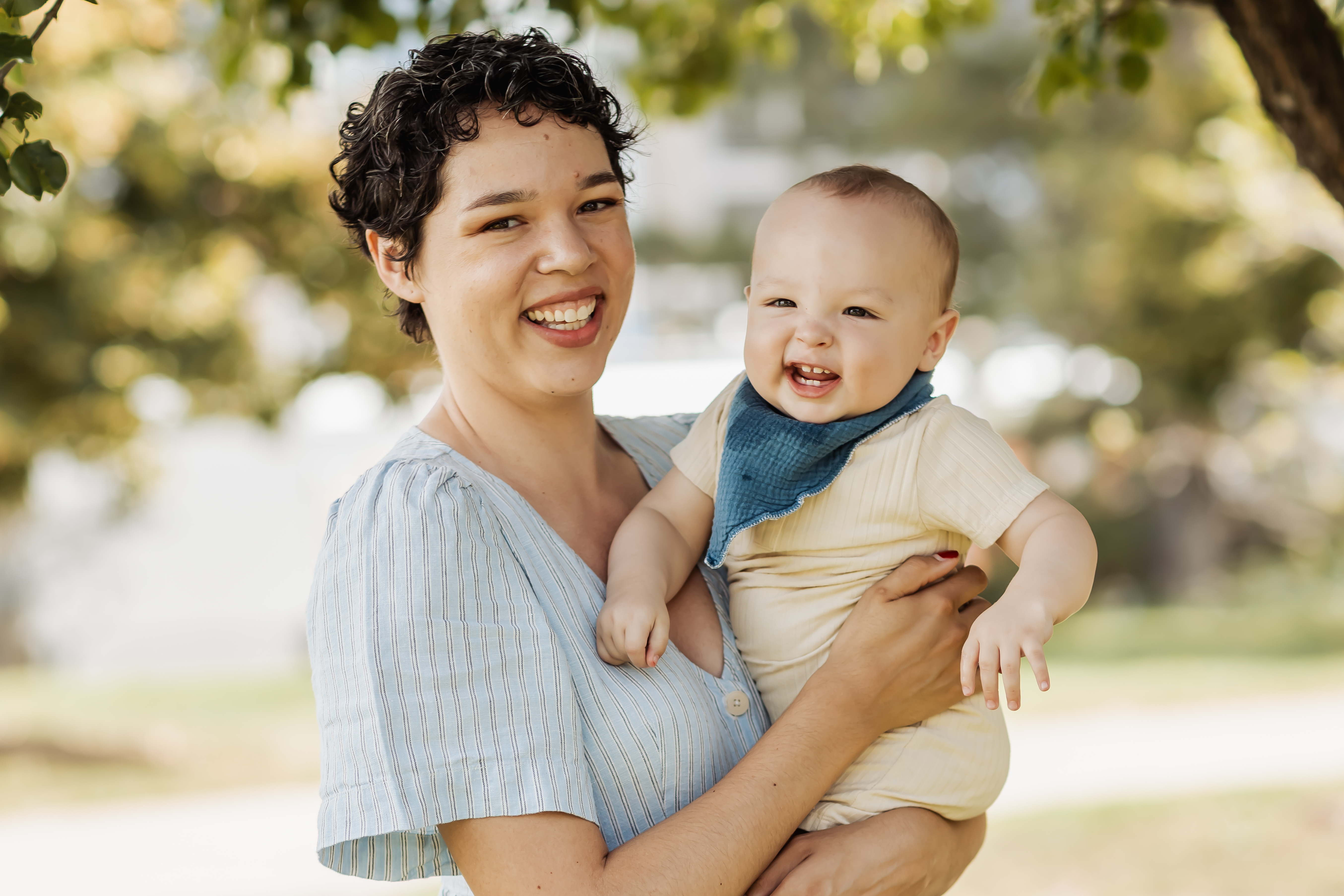 person smiling holding a happy baby